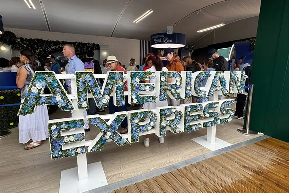 Crowds in the Fan Experience around the floral American Express sign
