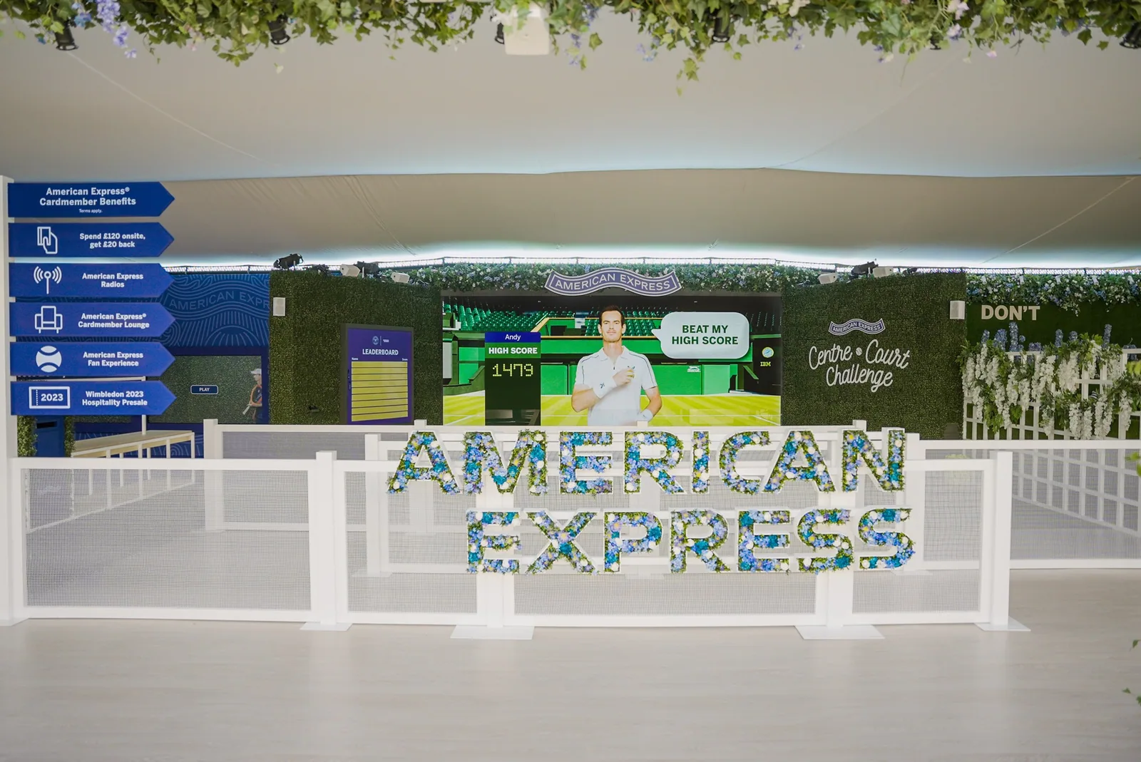 3D render of the Fan Experience: a floral American Express sign in front of the Centre Court Challenge lanes, with benefit signage on the left